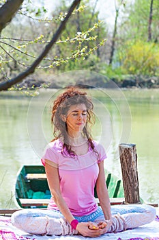 Young woman practice yoga outdoor by the lake healthy lifestyle concept