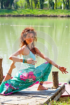 Young woman practice yoga outdoor by the lake healthy lifestyle concept