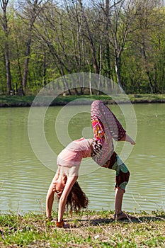 Young woman practice yoga outdoor by the lake healthy lifestyle concept full body shot