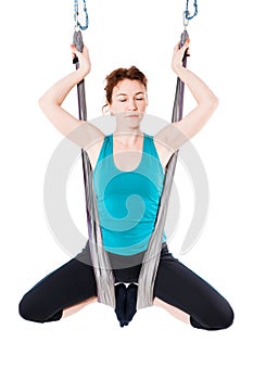 Young woman practices aerial anti-gravity yoga with a hammock