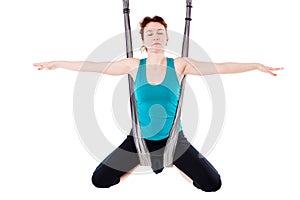 Young woman practices aerial anti-gravity yoga with a hammock