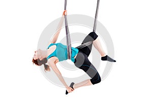 Young woman practices aerial anti-gravity yoga with a hammock