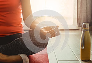 Young woman practices yoga in her apartment in the morning - concept of meditation, spirituality and psycho-physical well-being -