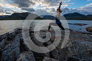 Young Woman Practices yoga, Lake Stavatn after sunset, Norway