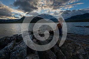 Young Woman Practices yoga, Lake Stavatn after sunset, Norway