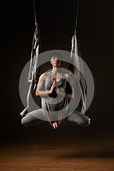 Young woman practicing aerial yoga hammock