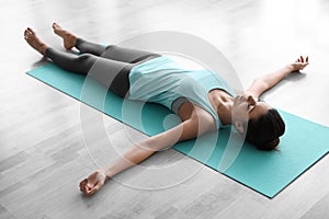 Young woman practicing corpse asana in studio. Savasana pose