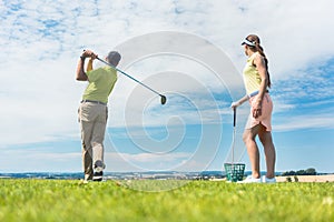 Young woman practicing the correct move during golf class
