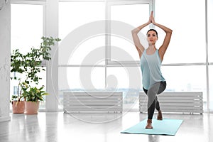 Young woman practicing crescent asana in studio. High lunge pose