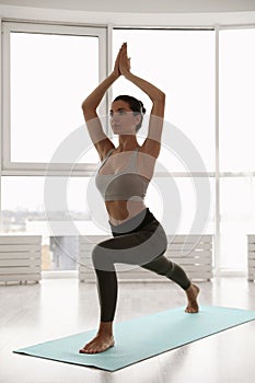 Young woman practicing crescent asana in studio. High lunge pose
