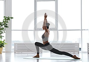 Young woman practicing crescent pose in studio