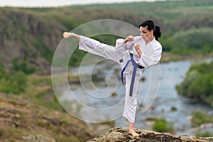 Young woman practicing kickboxing outdoors