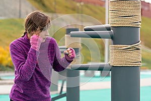 Young woman practicing martial arts alone on the sports ground with traditional dummies