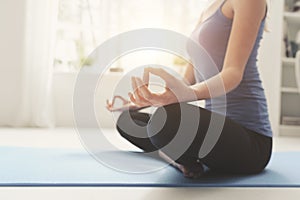 Young woman practicing meditation at home