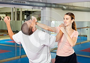 Young woman practicing palm heel strike in chin in self-defense training