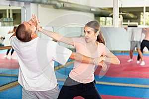 Young woman practicing palm heel strike in chin in self-defense training