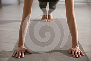 Young woman practicing plank asana in yoga studio. Phalankasana pose