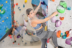 Young woman practicing rock climbing on climbing wall