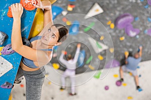 Young woman practicing rock climbing on climbing wall