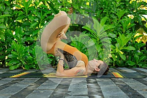 Young woman practicing Salamba Sarvangasana, Shoulderstand, inverted asana in hatha yoga. Legs in Lotus pose. Bali, Indinesia