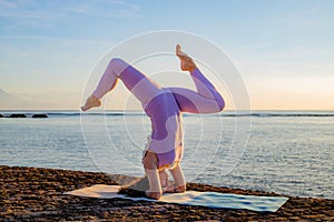 Young woman practicing Salamba Shirshasana, Yoga Headstand is an inverted asana. Self care concept. Bali, Indonesia