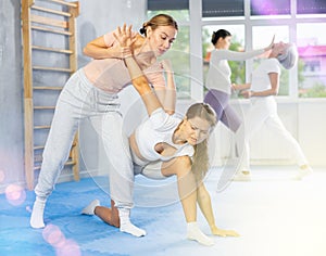 Young woman practicing wristlock with elbow blow during self defence training