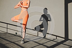 Young woman practicing yoga. Athletic body silhouette