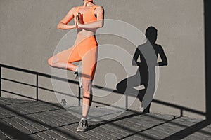 Young woman practicing yoga. Athletic body silhouette, healthy lifestyle
