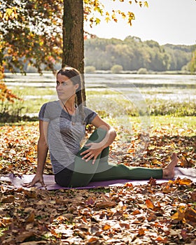 Young woman practicing yoga in the autumn leaves