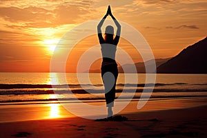 A young woman practicing yoga on the beach at sunset