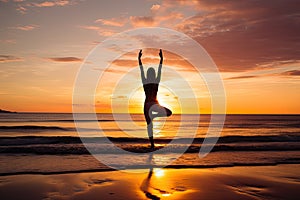 A young woman practicing yoga on the beach at sunset