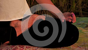 Young woman practicing yoga on the beach at sunset