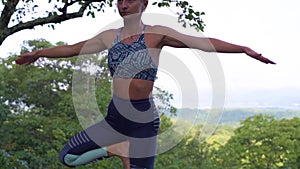 Young woman is practicing yoga at beautiful exotic place on the top of a mountain in slow motion. Yoga and meditation