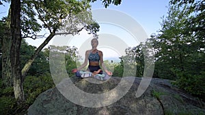 Young woman is practicing yoga at beautiful exotic place on the top of a mountain in slow motion. Yoga and meditation