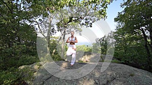 Young woman is practicing yoga at beautiful exotic place on the top of a mountain in slow motion. Yoga and meditation