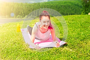 Young woman practicing yoga in beautiful nature. Lake shore in morning sunny day