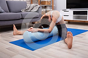 Young Woman Practicing Yoga With Bolster