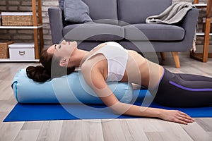 Young Woman Practicing Yoga With Bolster photo