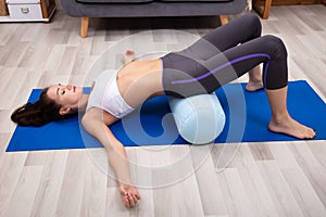 Young Woman Practicing Yoga With Bolster photo