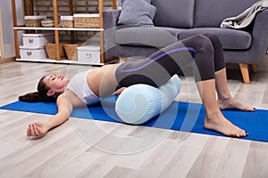 Young Woman Practicing Yoga With Bolster photo