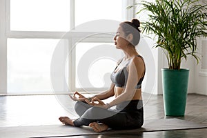 Young woman practicing yoga, doing Easy Seat exercise, Sukhasana