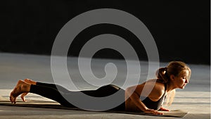 A young woman practicing yoga, doing an exercise on cobra, pose of bhujangasana.