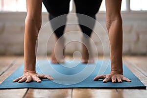 Young woman practicing yoga, doing Push ups or press ups