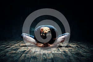 Young woman practicing yoga doing reclined goddess pose asana in dark room