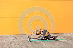 Young woman practicing yoga, doing revolved head to knee forward exercise, parivrtta janu sirsasana pose