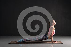 Woman practicing yoga, doing urdhva mukha svanasana, upward facing dog pose