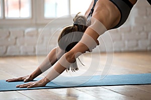 Young woman practicing yoga, Downward facing dog exercise close