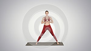 Young woman practicing yoga, finishes doing Utthita parsvakonasana exercise on gradient background.