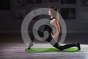 Young woman practicing yoga on green mat
