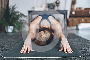 Young woman practicing yoga at her home